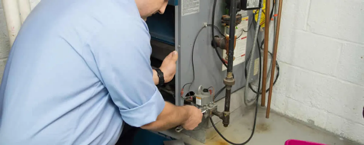 Furnace repair technician inspecting and servicing a home heating system in Boise, ID